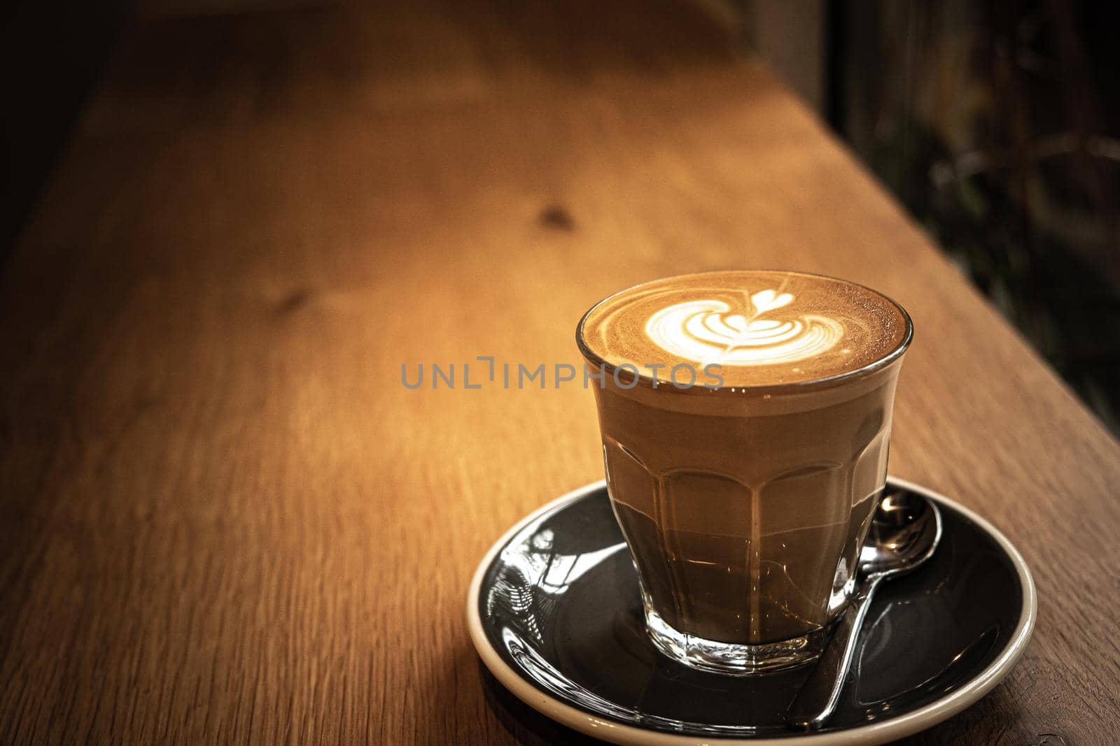 A cup of coffee latte top view with leaf shape foam