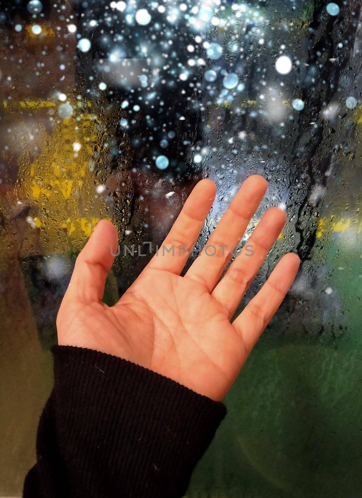 hand of young woman at the window in the rain by Petrichor