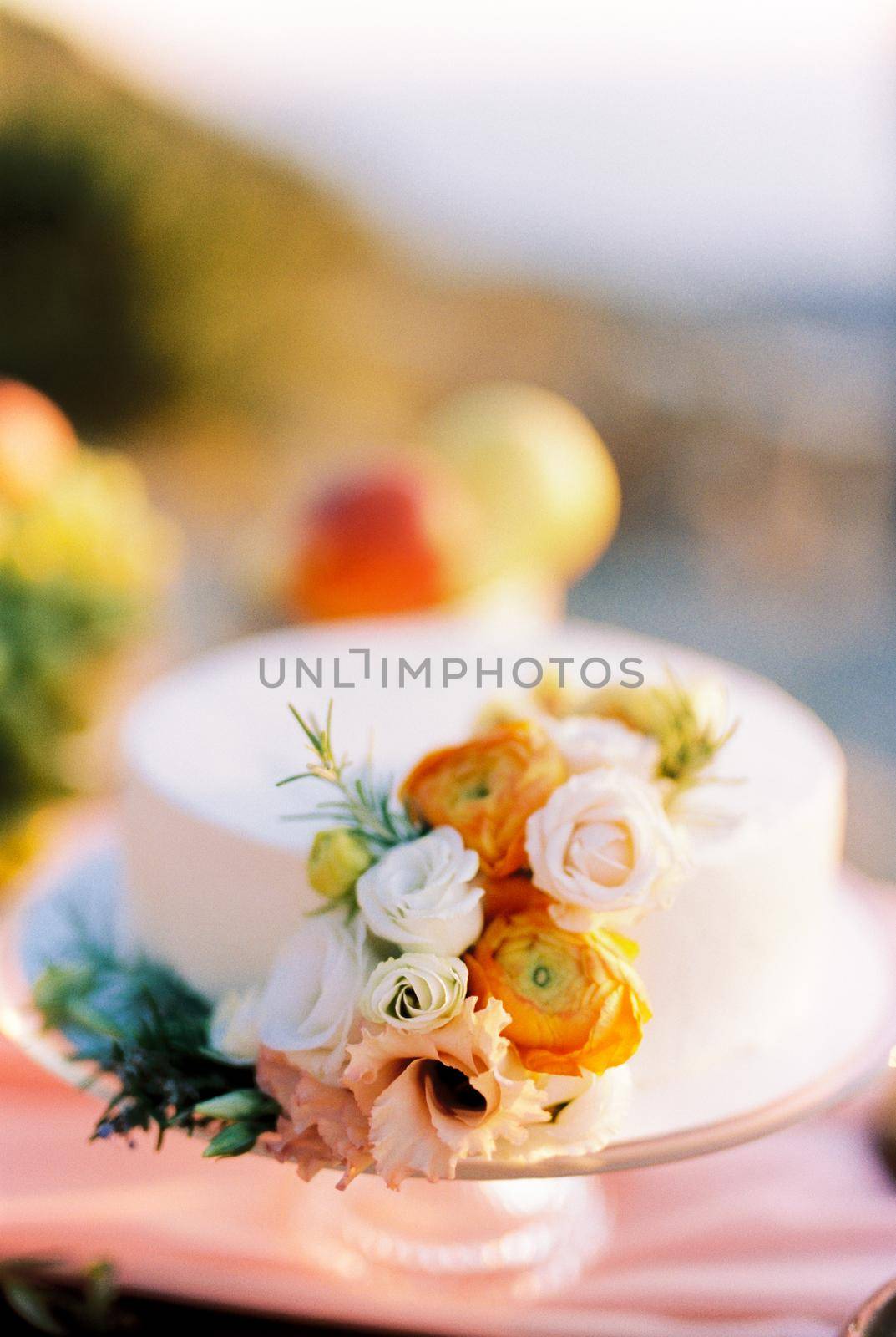 Wedding cake decorated with flowers stands on the table. High quality photo