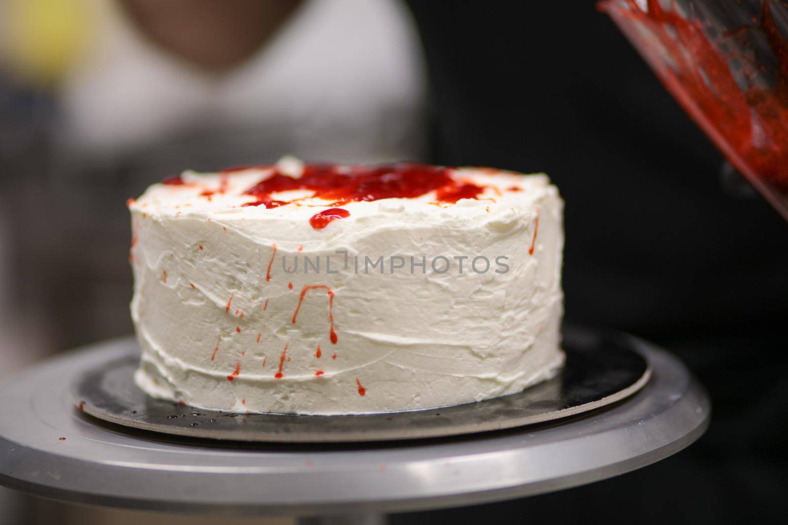 designer chef decorating white red bloody horror crime cake for halloween party by verbano