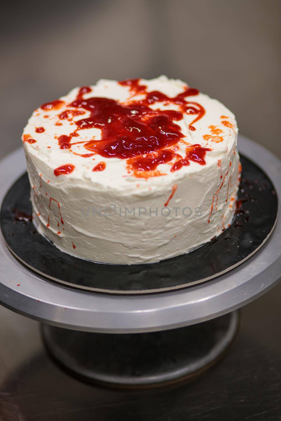 designer chef decorating white red bloody horror crime cake for halloween party by verbano