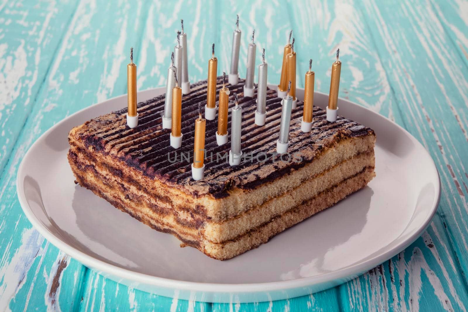 birthday cake with candles on blue wooden background
