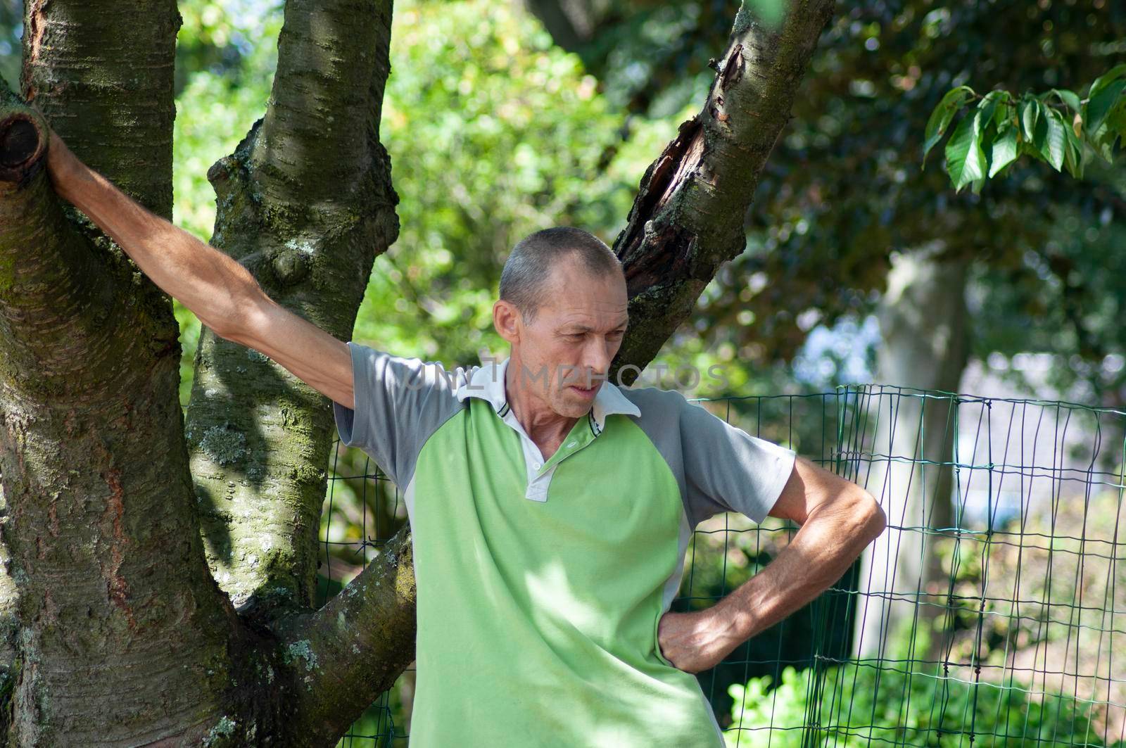 gardener man in dirty work clothes, rolls a rusty cart with a bucket, spring work in the garden. High quality photo