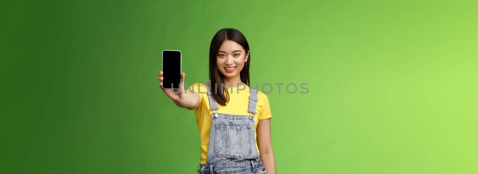 Self-assured attractive asian brunette show smartphone screen, introduce new telephone appllication, beating score cellphone game, smiling delighted, give recommendation follow own blog by Benzoix