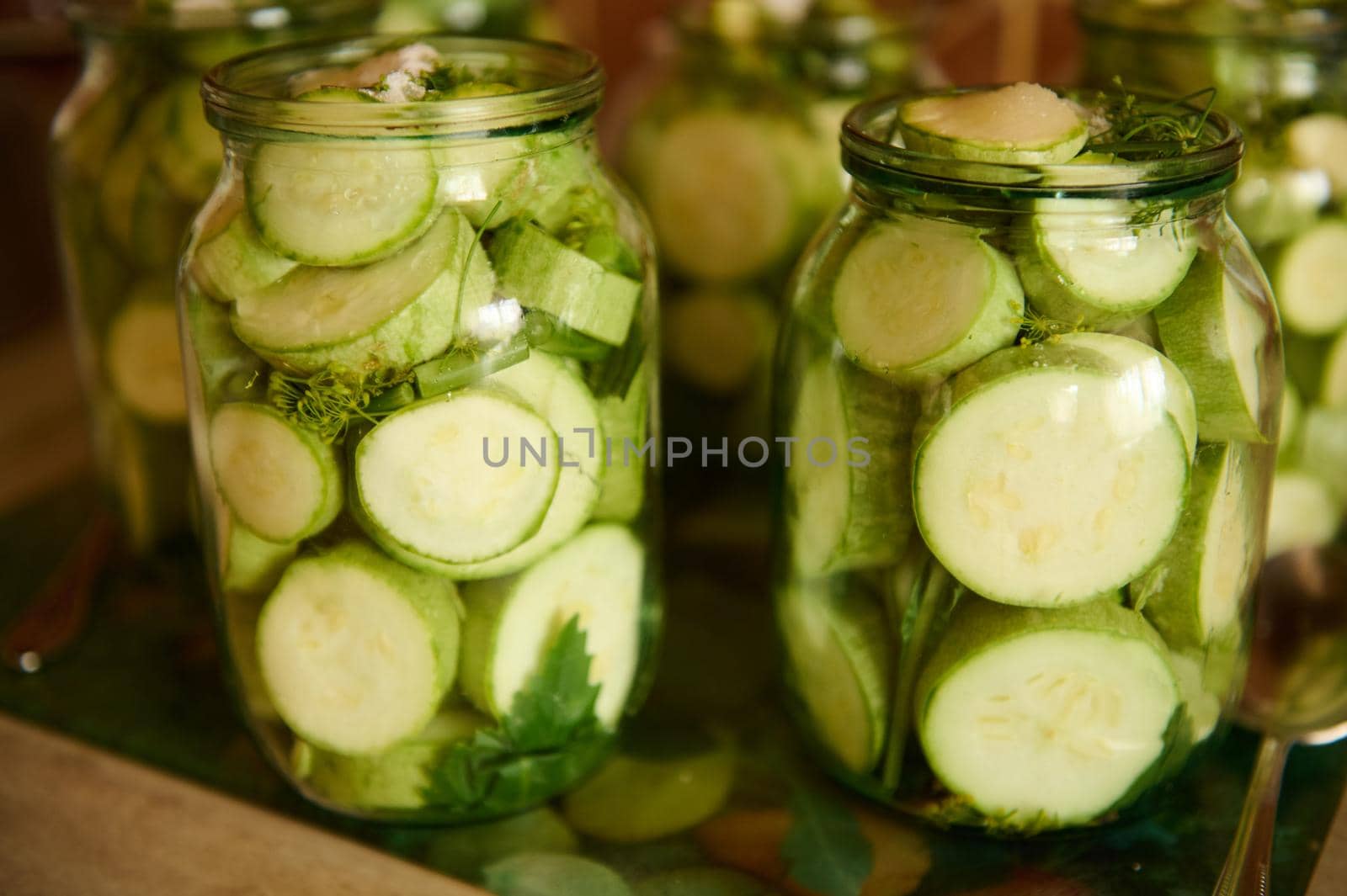 Pickling Canning Marinating. Preserving vegetables for the winter. Organic sliced courgettes, zucchini pickled in brine by artgf