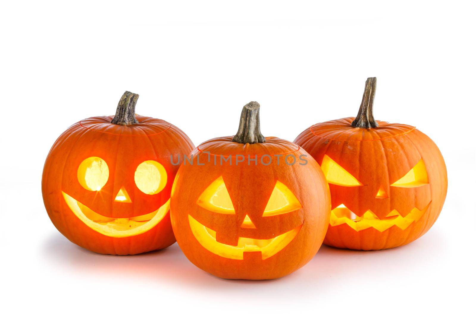 Three Halloween glowing lantern pumpkins in a row isolated on white background