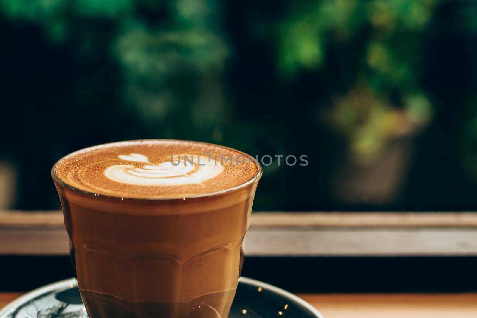 A cup of coffee latte top view with leaf shape foam by Petrichor
