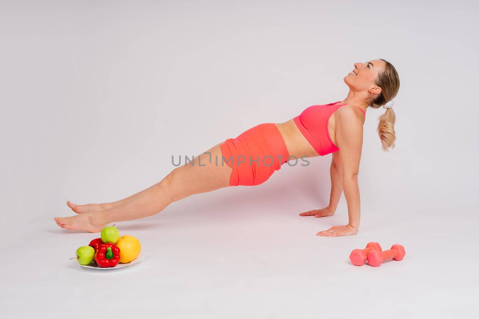 Healthy eating, happy woman with fruits and vegetables is eating an apple