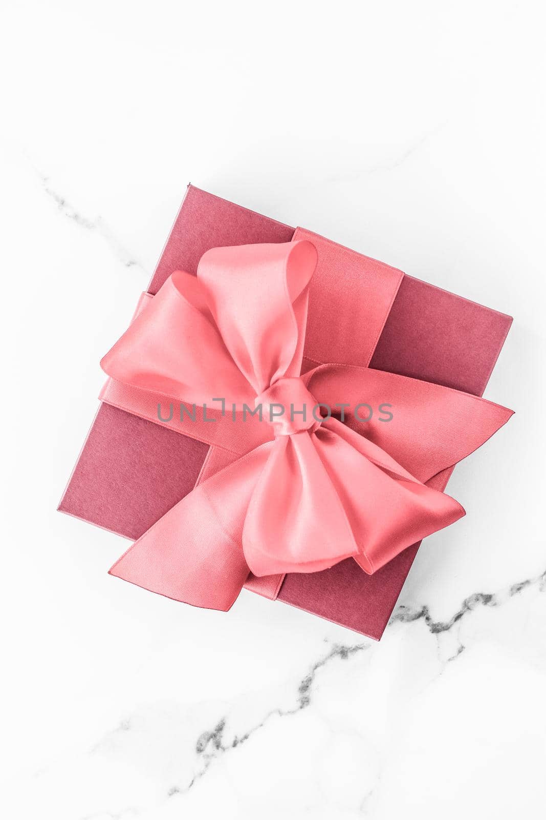 Birthday, wedding and girly branding concept - Coral gift box with silk bow on marble background, girl baby shower present and glamour fashion gift for luxury beauty brand, holiday flatlay art design