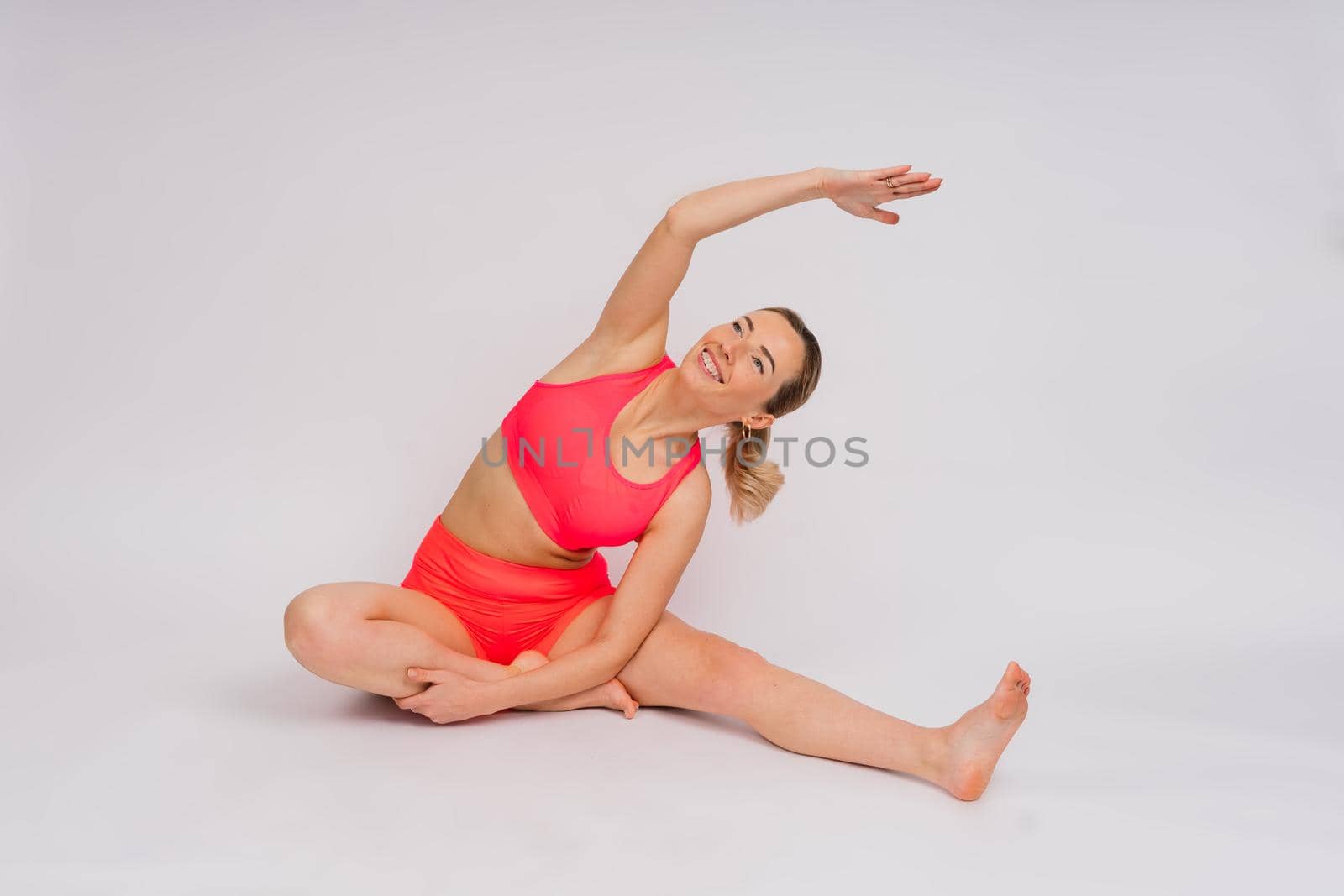 Full length portrait of smiling young woman in sportswear isolated over studio background. by Zelenin