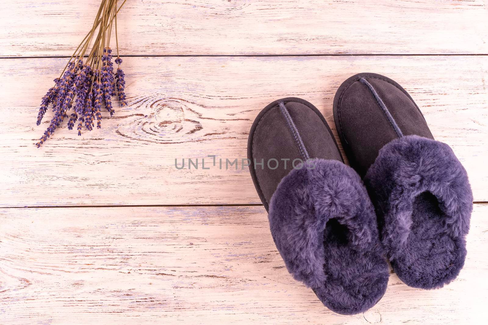 Soft blue woolen cozy slippers with lavender on wooden background by Iryna_Melnyk