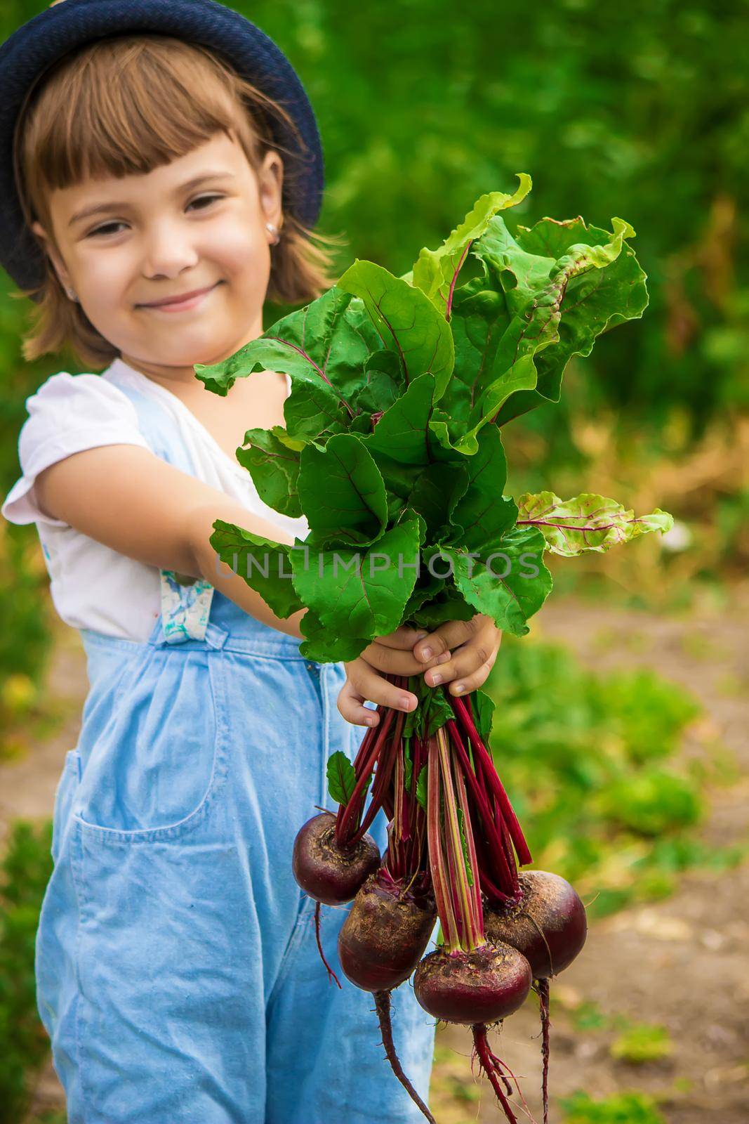 Child and vegetables on the farm. Selective focus. by yanadjana