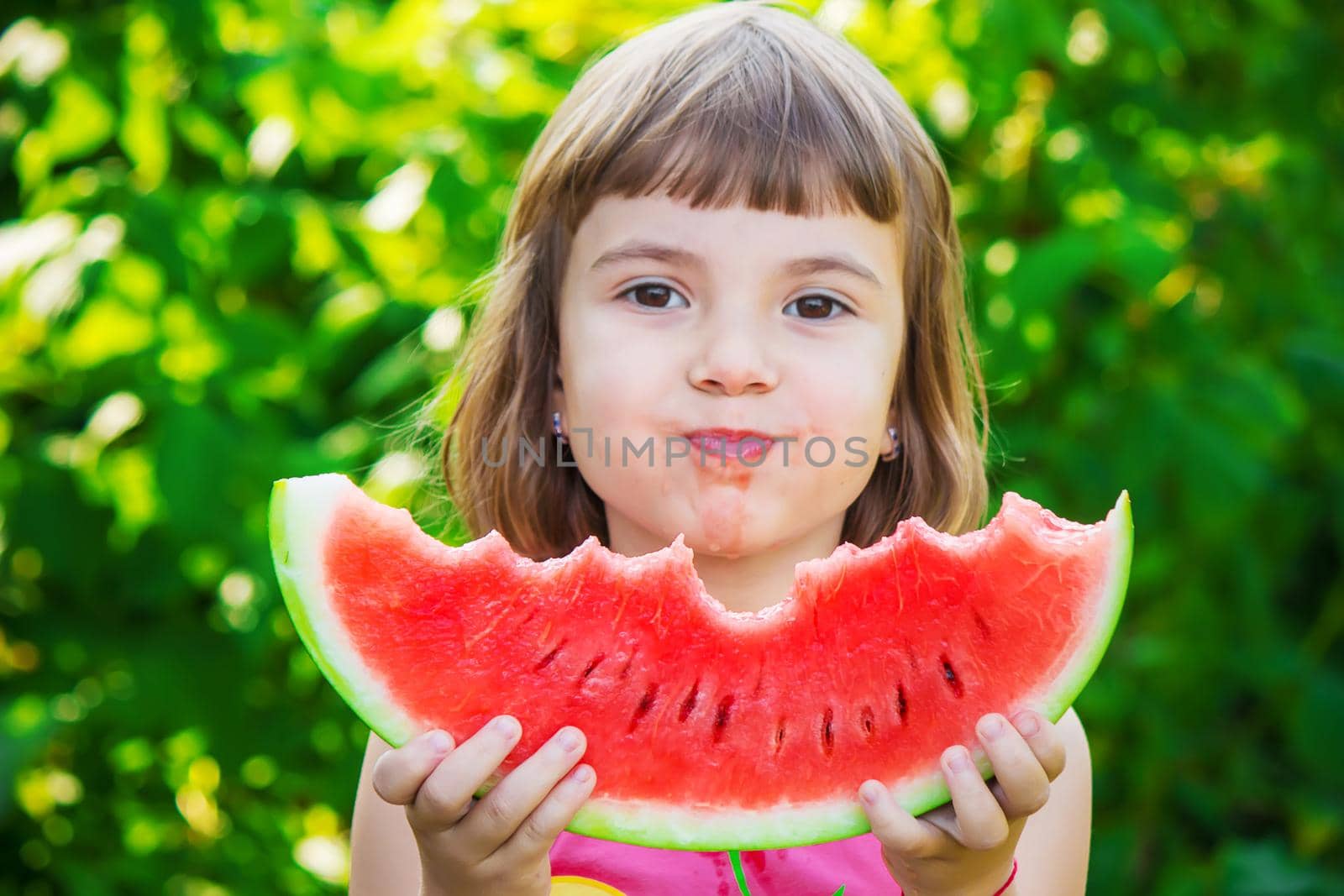 A child eats watermelon. Selective focus. Food nature.