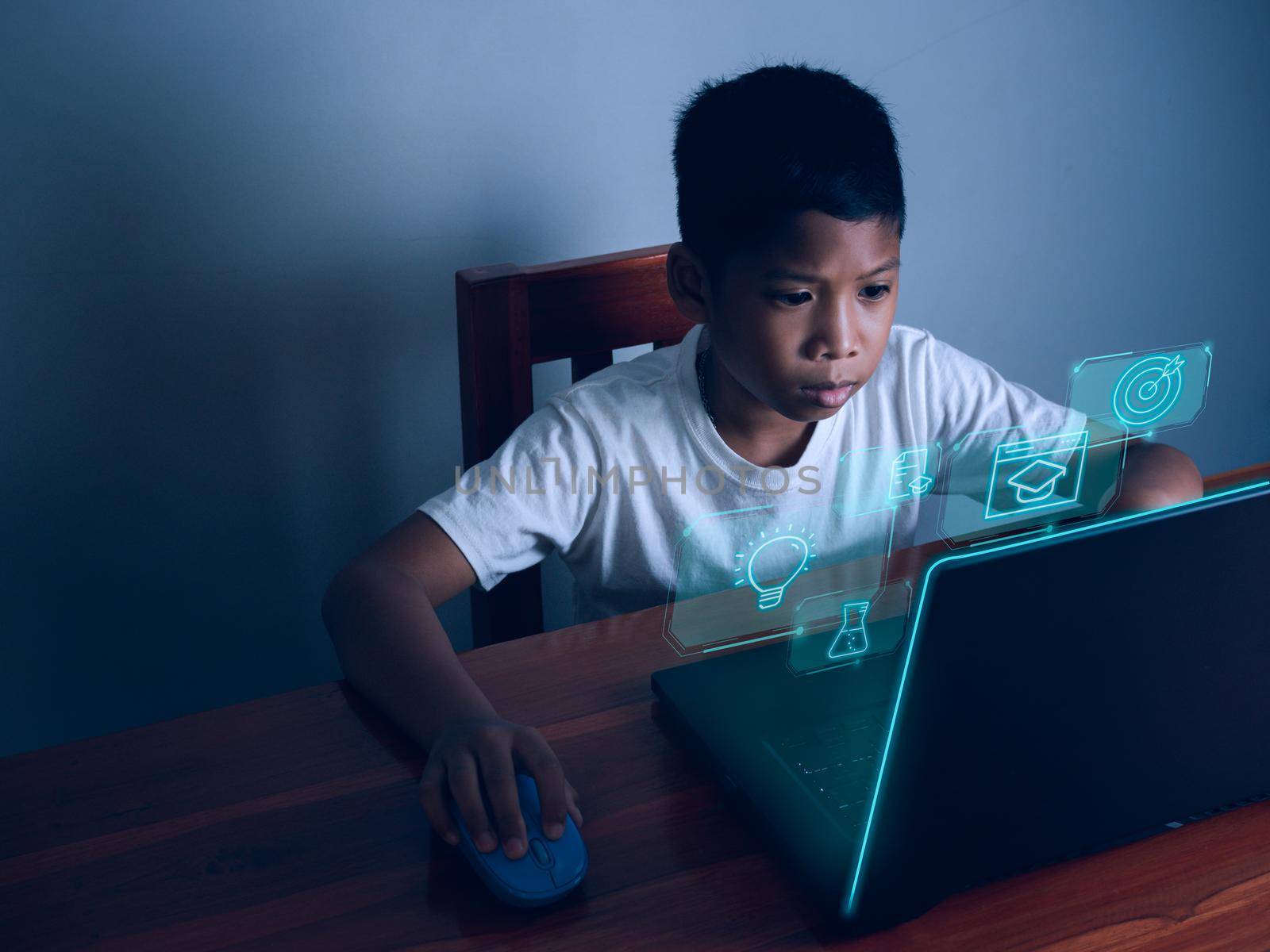 Education concept image. Creative idea and innovation. boy sitting staring at computer and there is an educational icon on the front. by Unimages2527