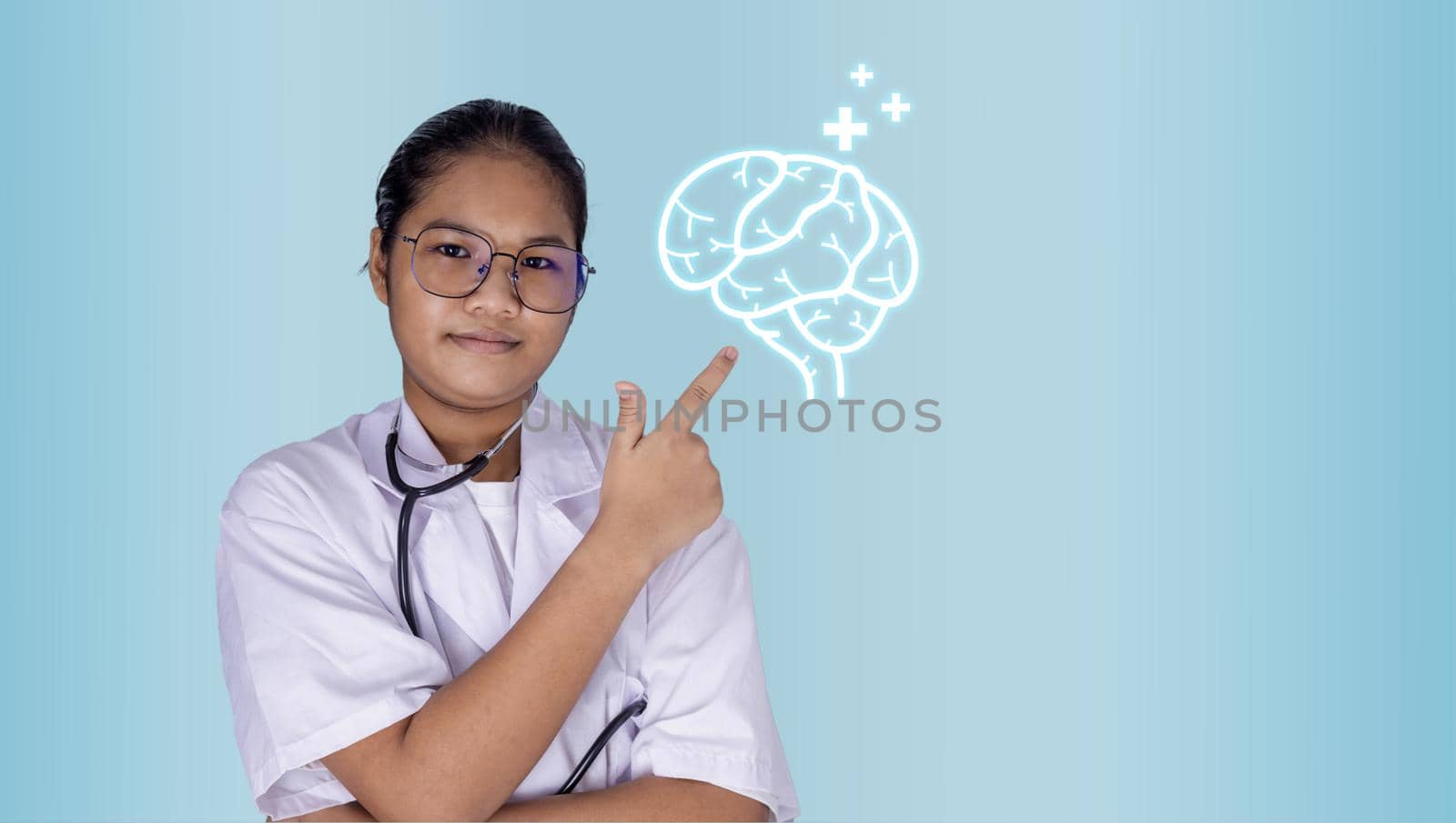 Portrait of a female doctor wearing glasses Standing with arms crossed on a light green background. hand pointing to brain icon. Concepts of medicine, disease treatment and health.