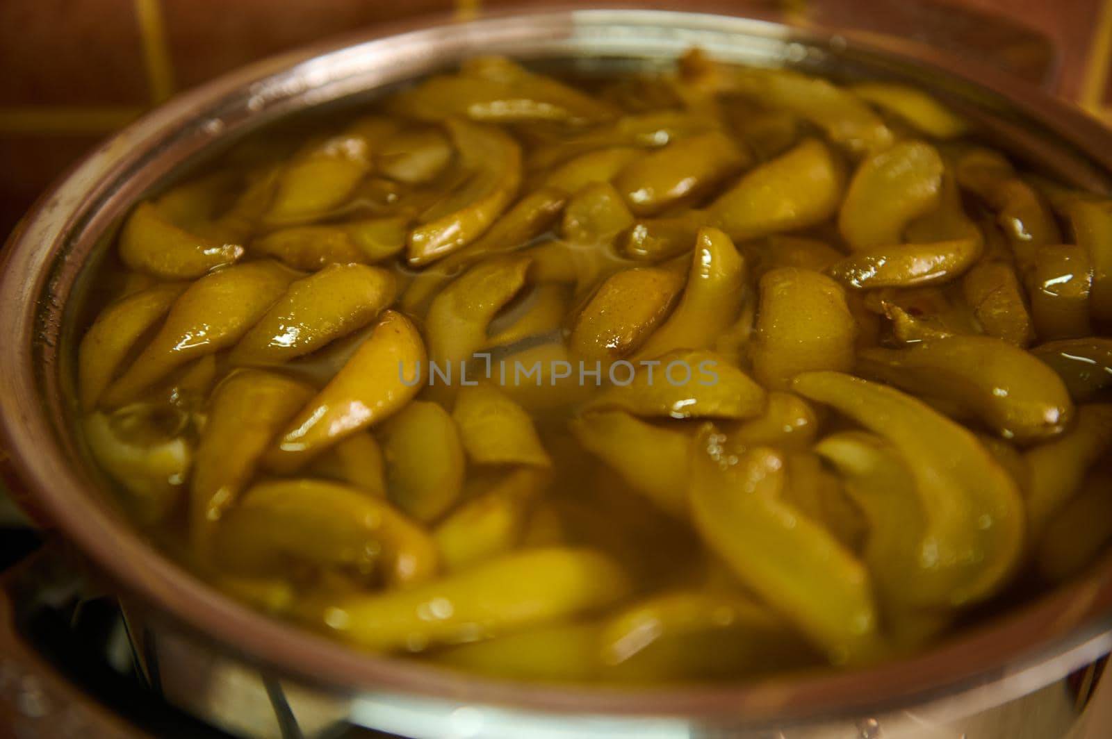 High angle view sliced organic pears, stirred with sugar in a metal bowl. Preparing homemade jam. Canning food. Marmalade. Confiture. Selective focus. Making preserves for the winter. Close-up