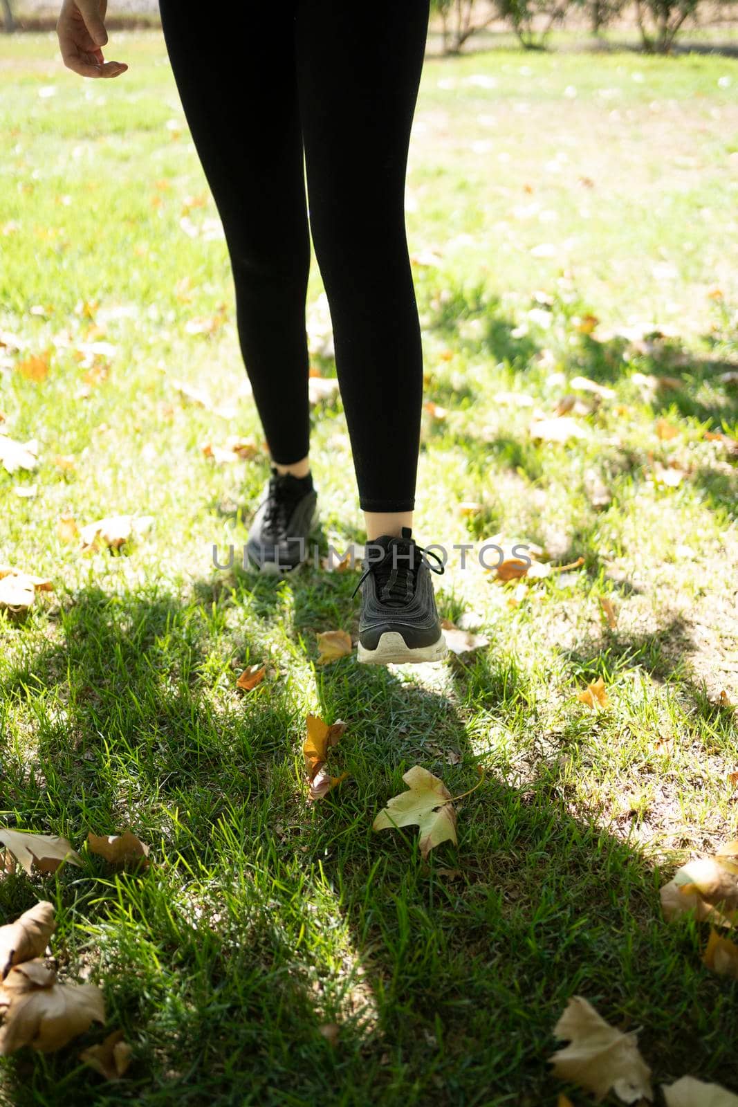 young woman wearing sport shoes jogging in the park. by barcielaphoto