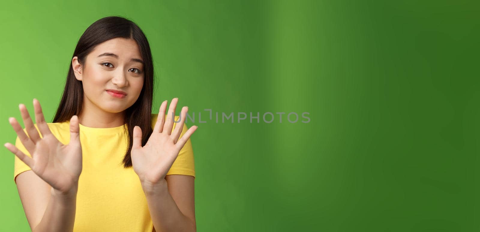 Modest cute insecure timid asian girl waving hands no gesture, step back, smirk, cringe aversion and dislike, refusing suspiciosu offer, rejecting proposal, stand green background by Benzoix