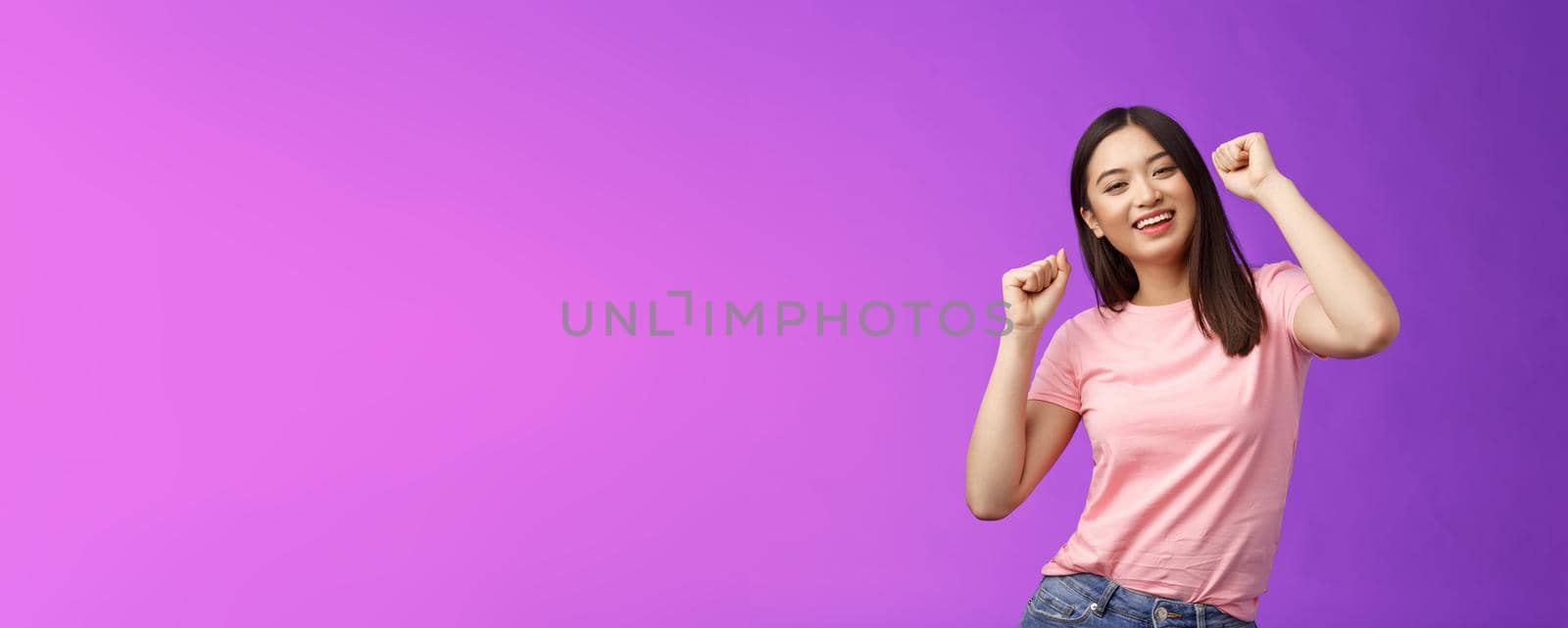 Joyful glamour asian attractive girl having fun enjoy awesome party feeling carefree, fist pump during dance, smiling broadly like good music, attend concert, stand purple background by Benzoix