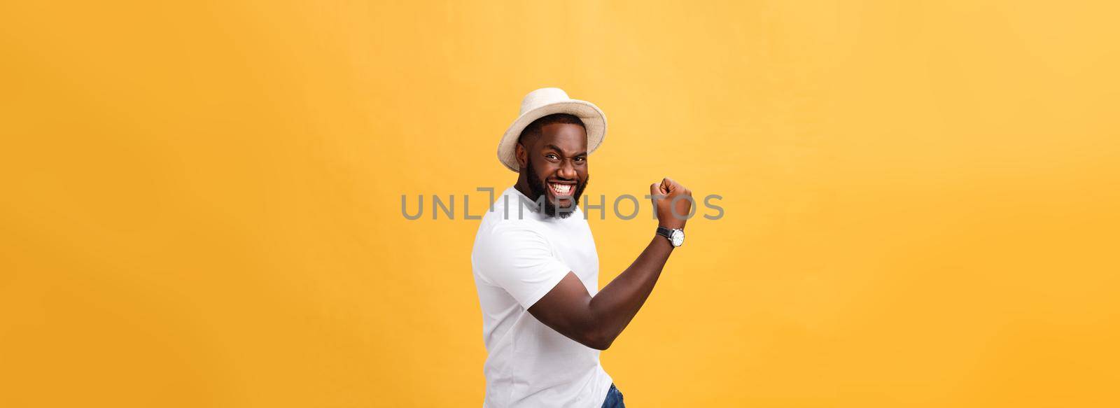 Handsome young Afro-American man employee feeling excited, gesturing actively, keeping fists clenched, exclaiming joyfully with mouth wide opened, happy with good luck or promotion at work.