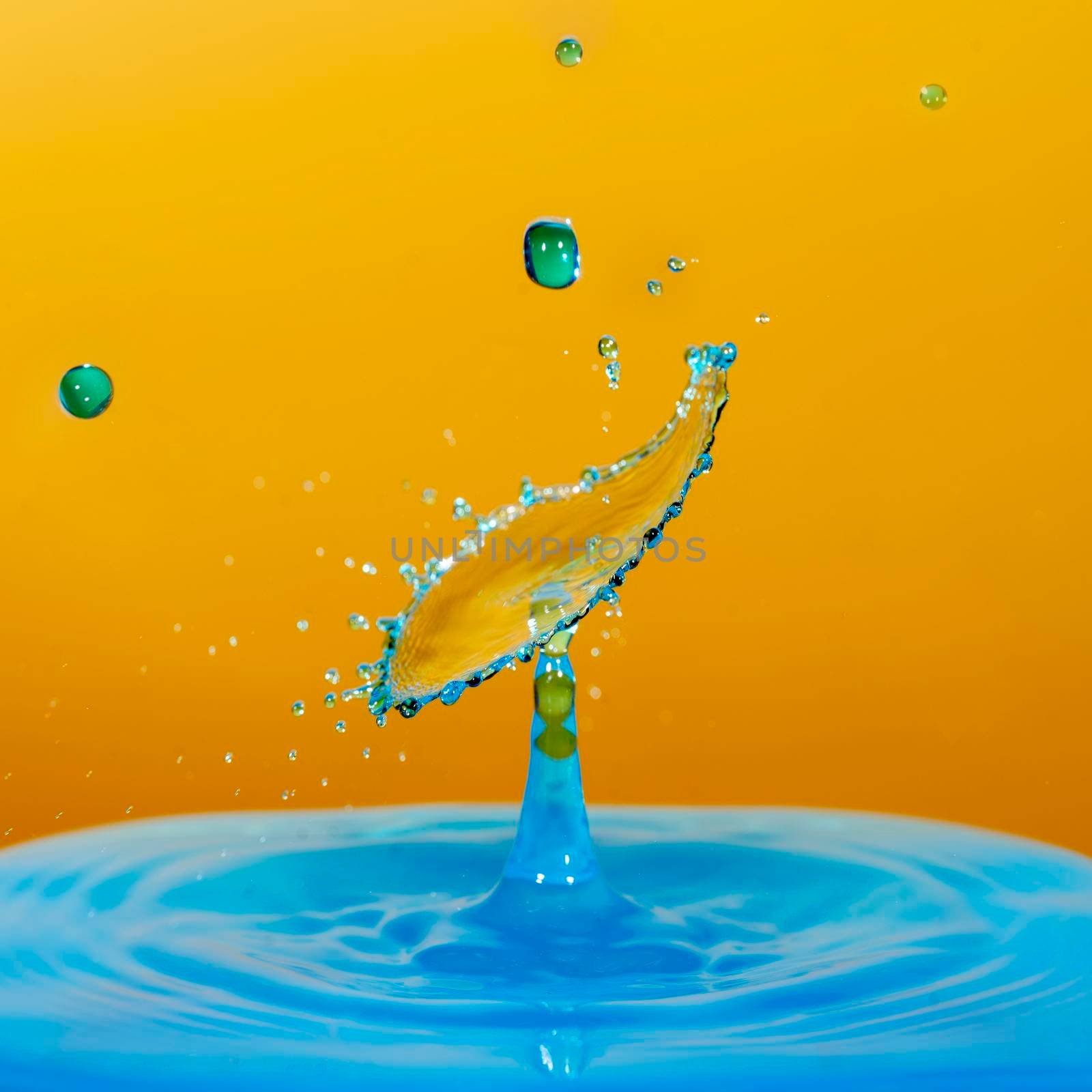 Fresh blue Water drop with droplet and rings on the yellow background by Iryna_Melnyk