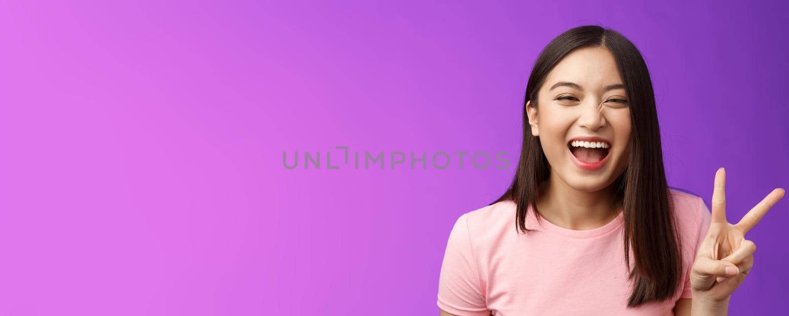 Headshot sincere carefree laughing asian girl having fun, show peace victory sign, joyfully look camera, express enthusiasm and happiness, enjoy funny friendly company, stand purple background by Benzoix