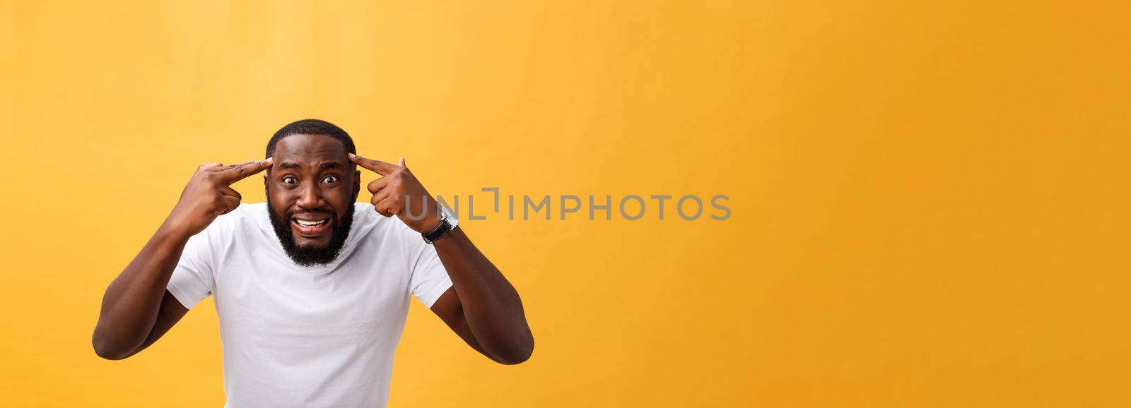 Portrait of african american man with hands raised in shock and disbelief. Isolated over yellow background. by Benzoix