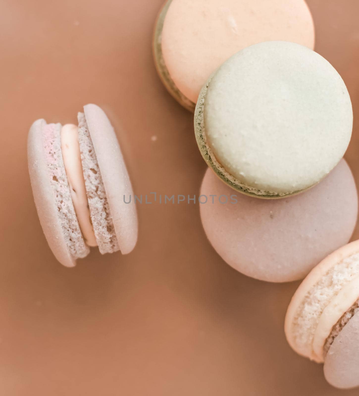 Pastry, bakery and branding concept - French macaroons on cream beige background, parisian chic cafe dessert, sweet food and cake macaron for luxury confectionery brand, holiday backdrop design