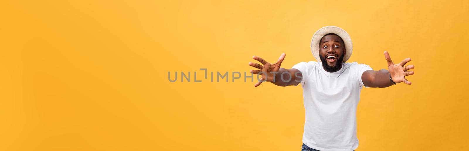 Come in my arms. Portrait of joyful friendly and happy handsome African American man with beard and short haircut, smiling broadly and pulling hands towards camera to give warm hug or cuddle