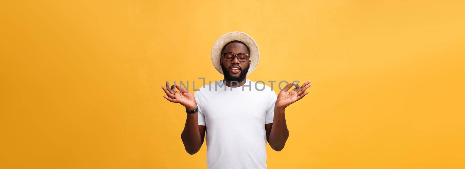 Closeup portrait of happy handsome, young man in meditation yoga mode, isolated on yellow background. Stress relief techniques concept