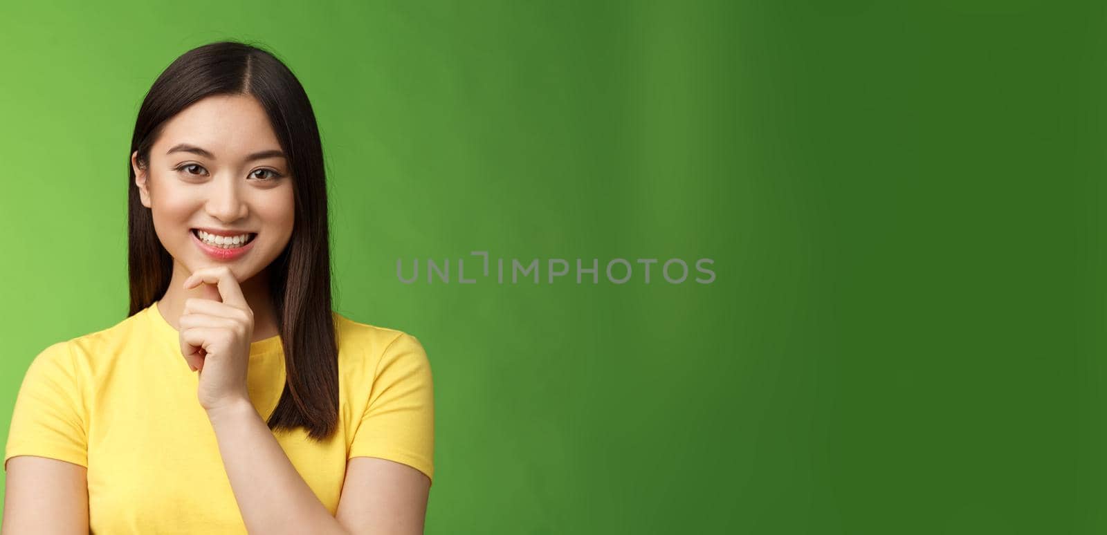 Smart assertive creative asian female student make interesting research assumption, smiling intrigued touch chin thoughtful, have good plan idea, thinking, ponder choices, green background by Benzoix