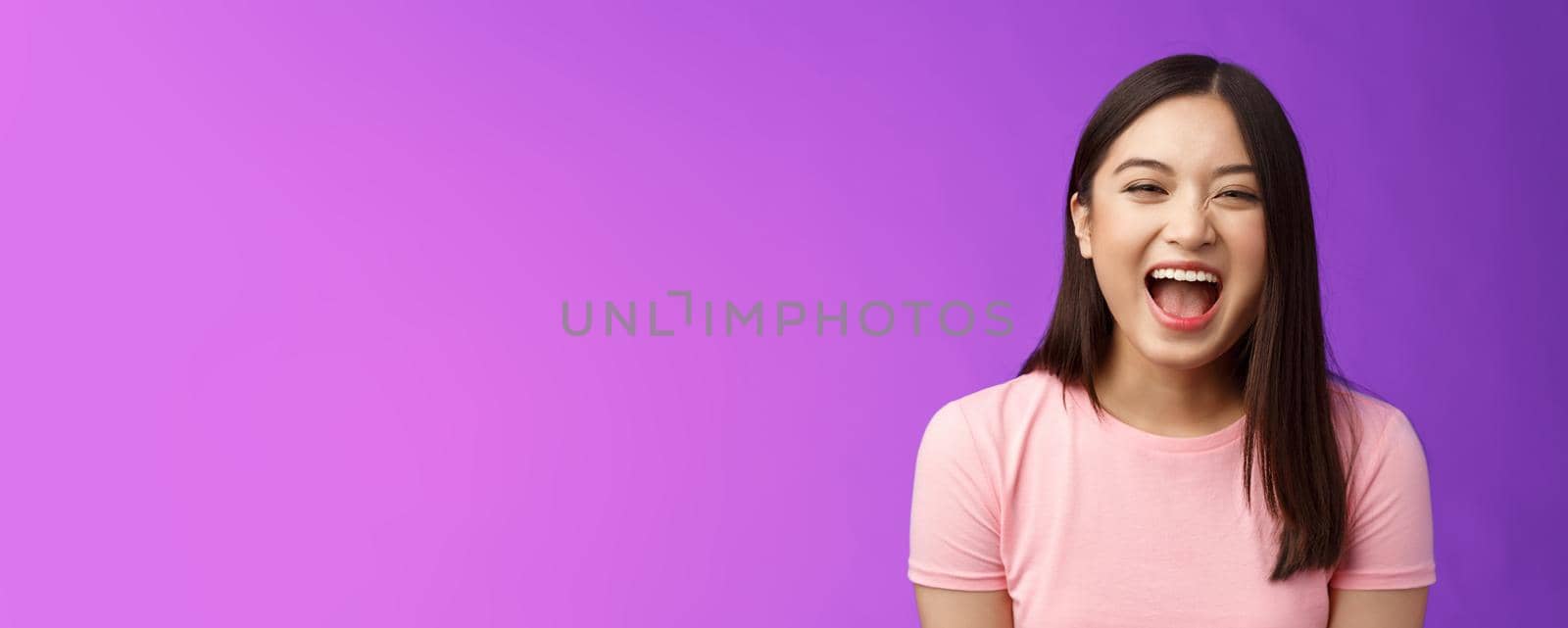 Close-up sincere carefree asian brunette laughing out loud, enjoy comedy movie, having fun, joking friends, stand entertained purple background amused, express positive emotions by Benzoix