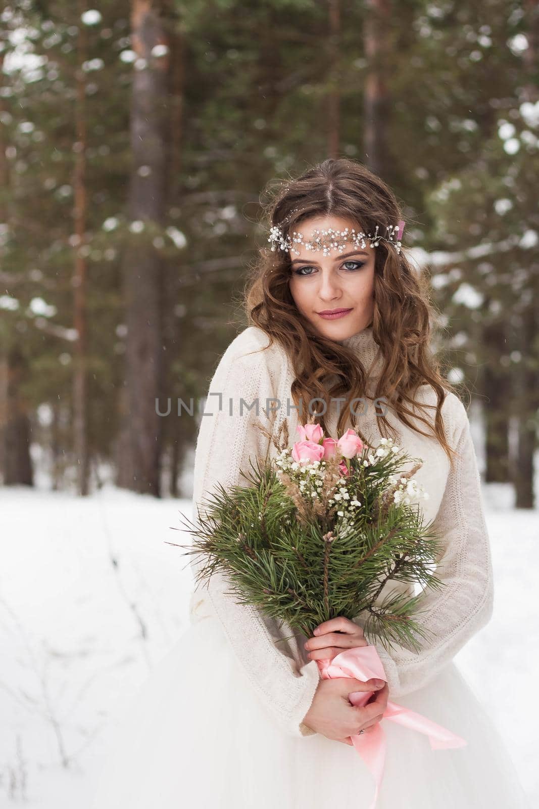 Beautiful bride in a white dress with a bouquet in a snow-covered winter forest. Portrait of the bride in nature by Annu1tochka