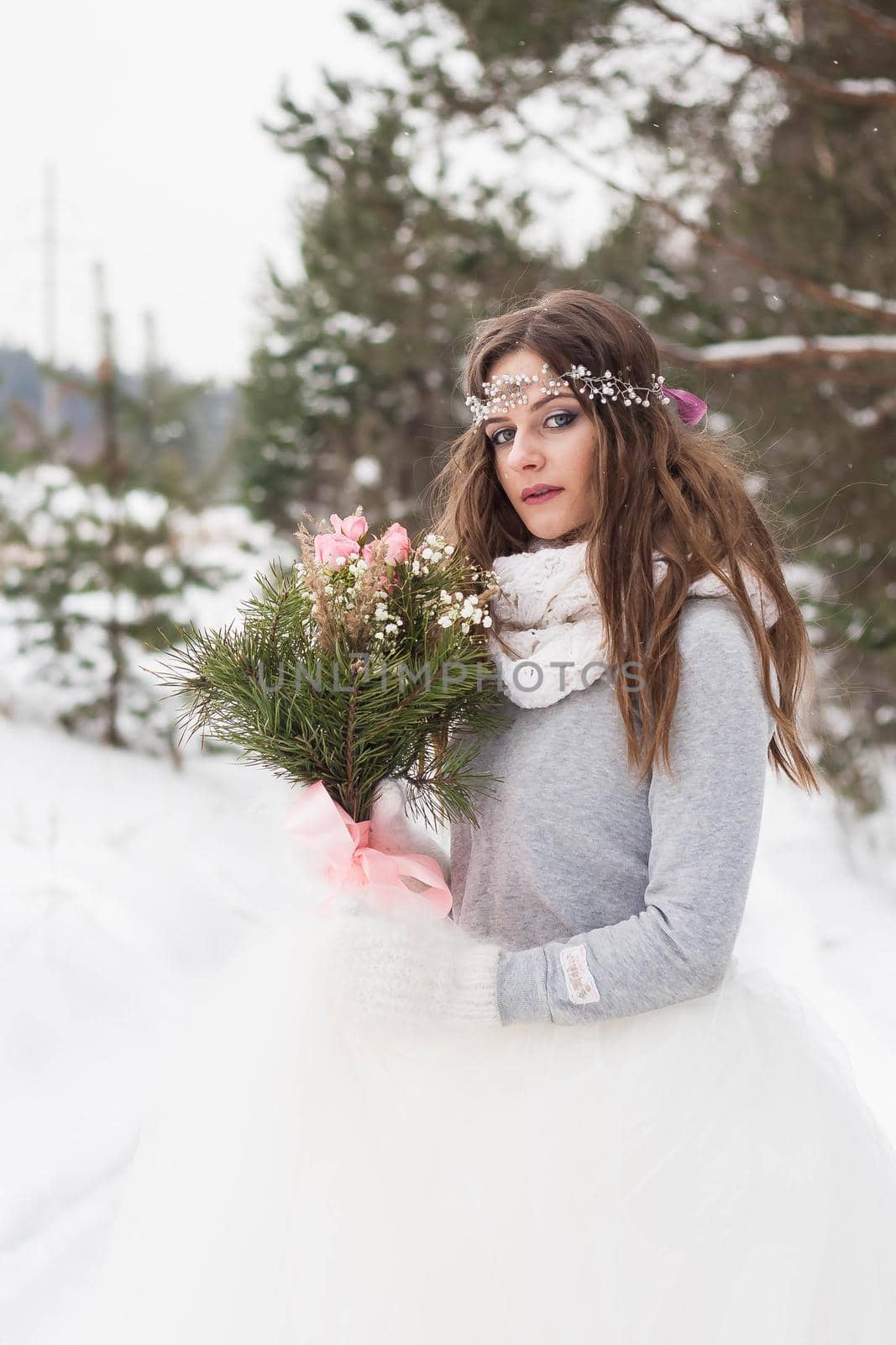 Beautiful bride in a white dress with a bouquet in a snow-covered winter forest. Portrait of the bride in nature by Annu1tochka