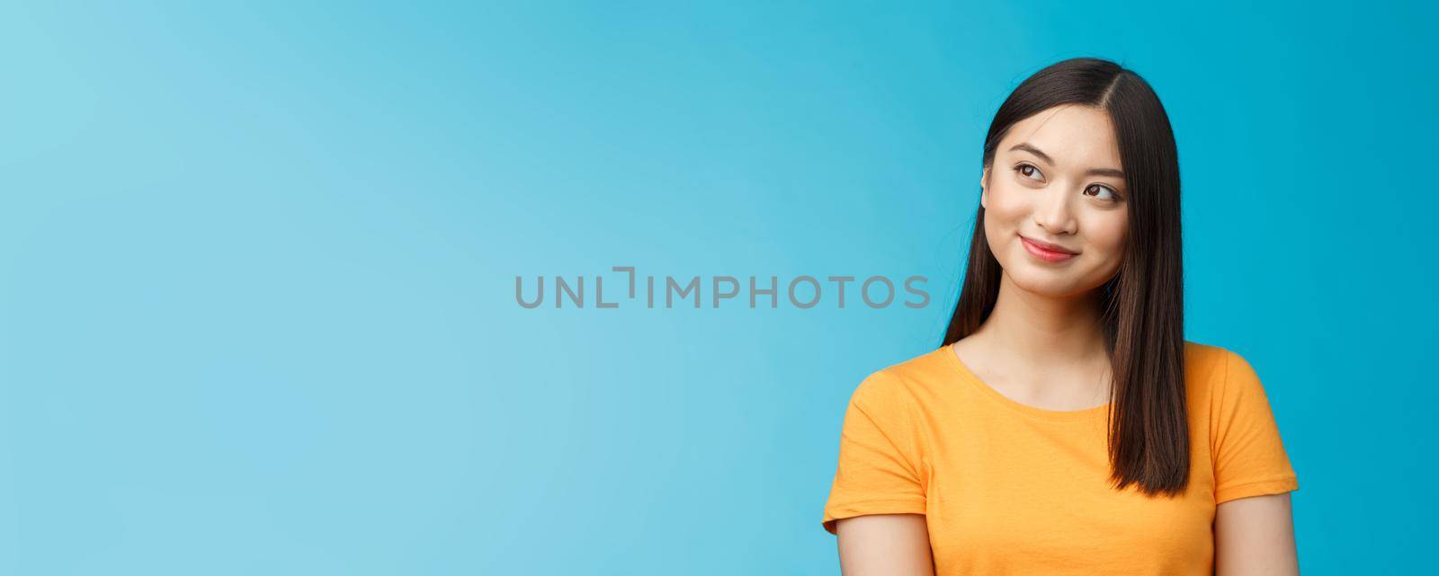 Close-up dreamy hopeful charming young asian woman wear yellow t-shirt turn sideways smiling delighted, contemplate beautiful summer scenery outside window sit office carefree, blue background by Benzoix