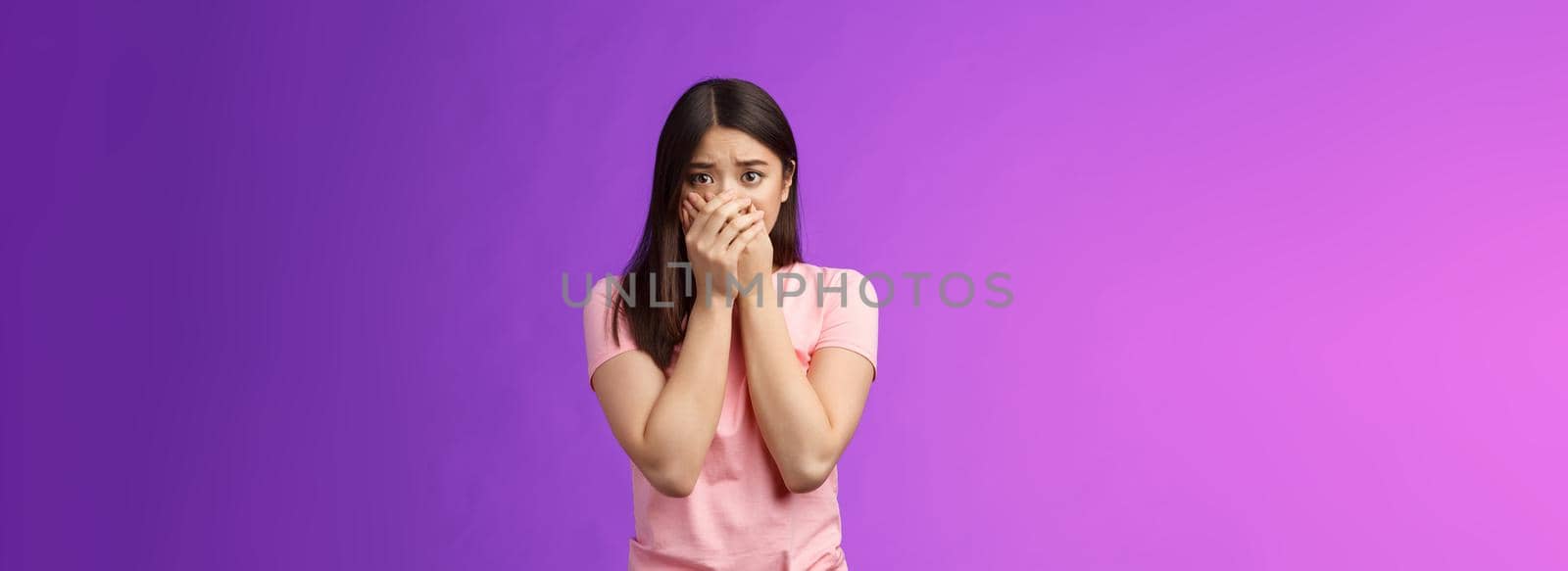 Shocked female asian victim frightened, gasping witness crime, close mouth hands, frowning, stare camera scared upset, make innocent terrified gaze, stand purple background by Benzoix