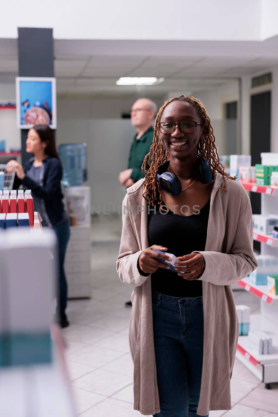 Portrait of cheerful client choosing to buy medicine, drugs, vitamins pharmaceutics shop. smiling pharmacy customer needed pharmaceutical medicament to cure illness. Shelves with health care products