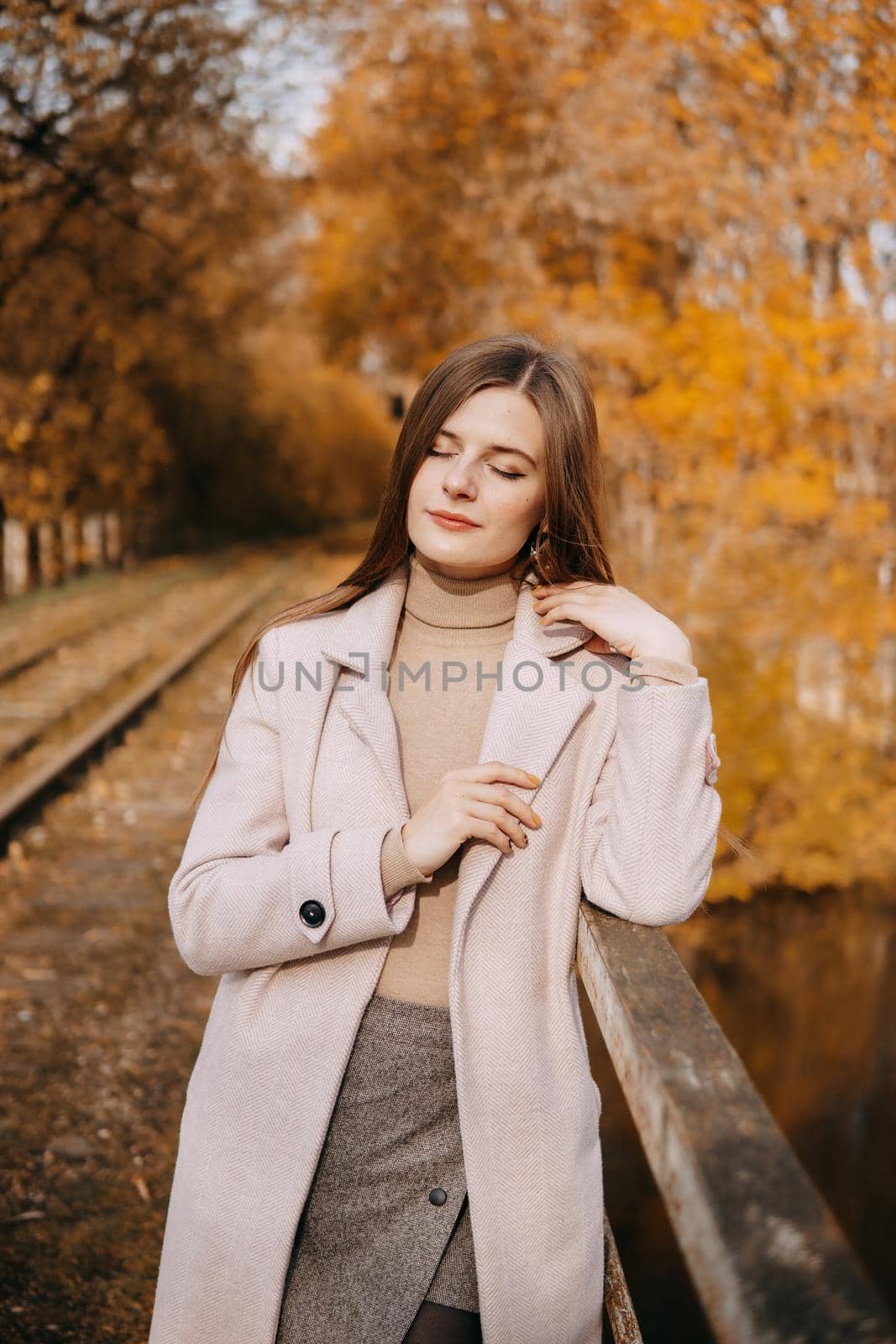 beautiful long-haired woman walks through the autumn streets. Railway, autumn, woman in a coat. by Annu1tochka