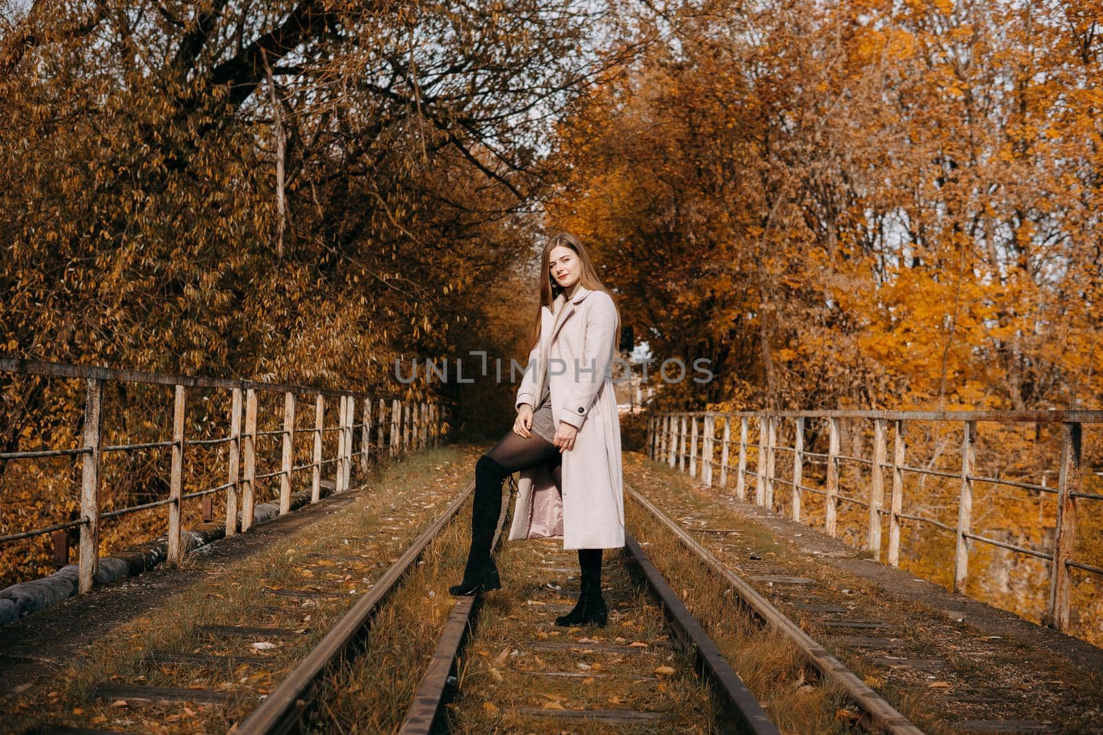beautiful long-haired woman walks through the autumn streets. Railway, autumn, woman in a coat. by Annu1tochka