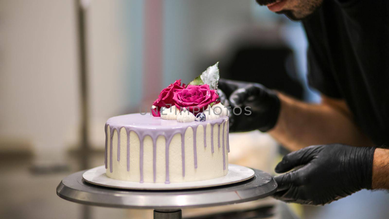 chef usign macaron , flowers and text sign for a celebration cake