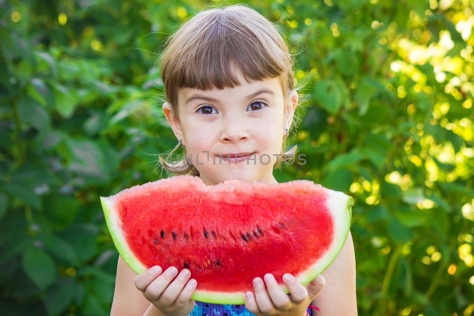 A child eats watermelon. Selective focus. Food nature.