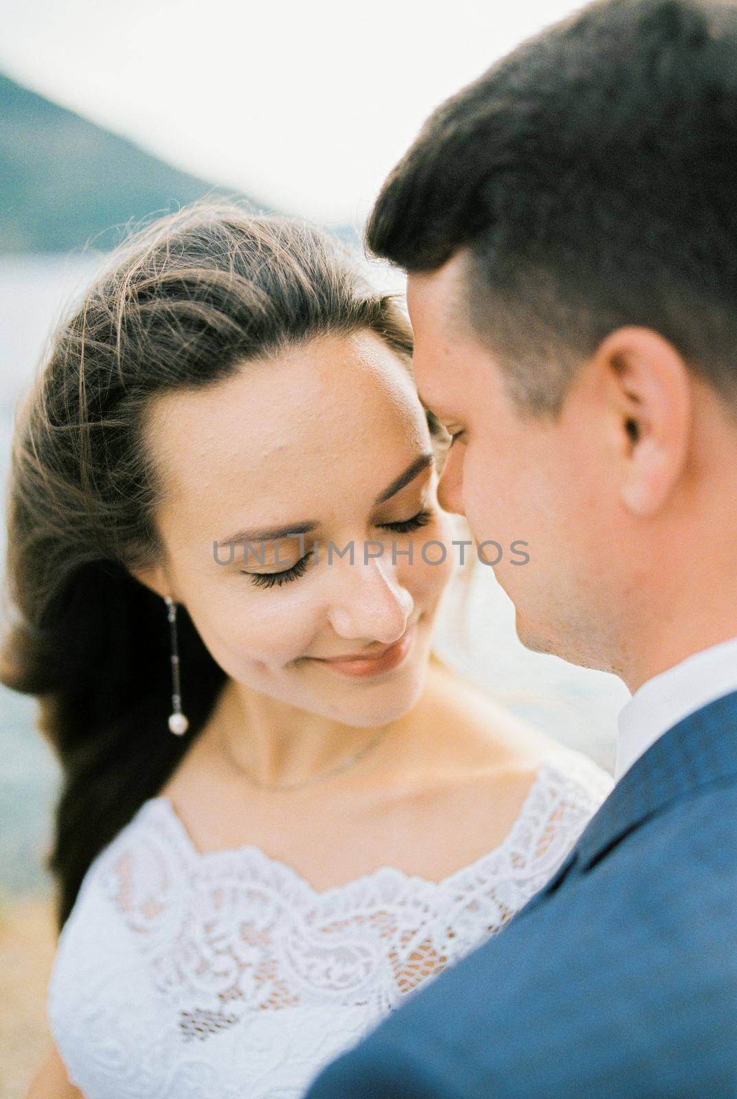 Groom tilted his face to the face of the smiling bride. Portrait. High quality photo