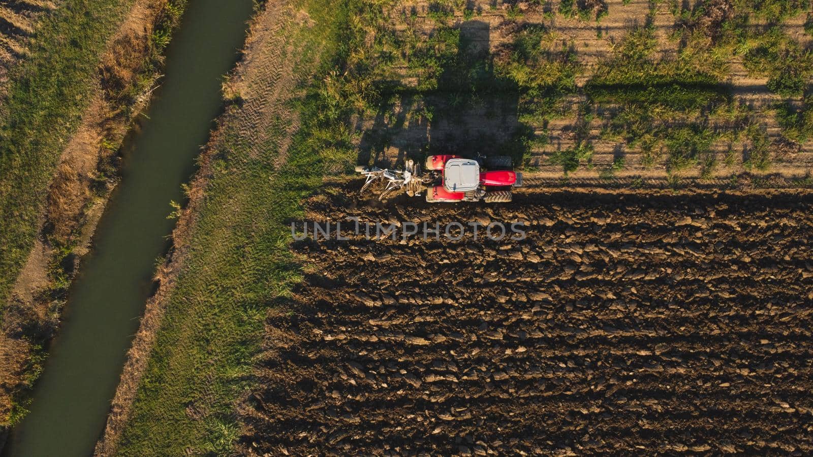 Aerial view with drone of tractor plowing the land in the countryside.