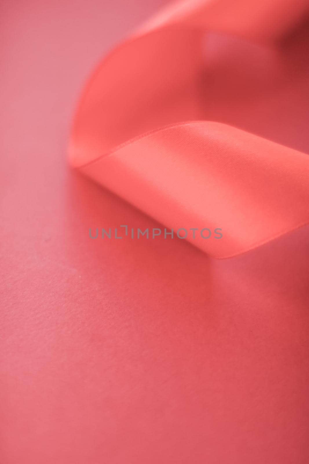 Branding, holidays and luxe brands concept - Abstract curly silk ribbon on coral background, exclusive luxury brand design for holiday sale product promotion and glamour art invitation card backdrop