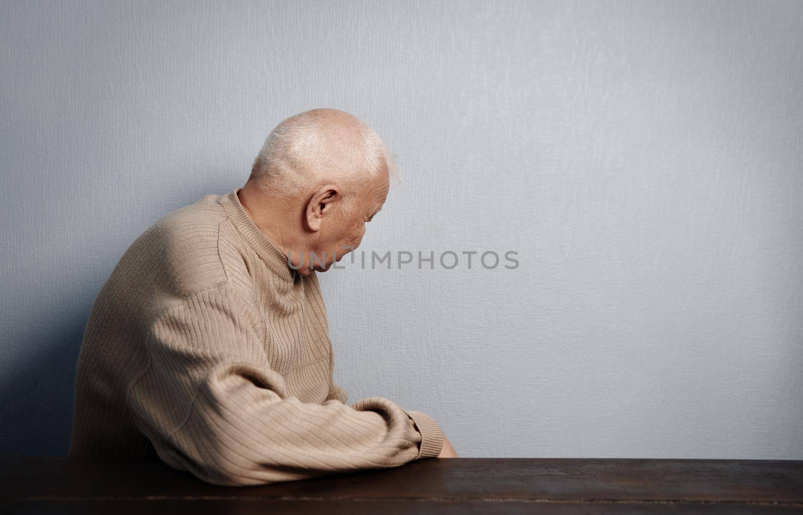 Back view on a turning back senior man sitting at the table by Novic