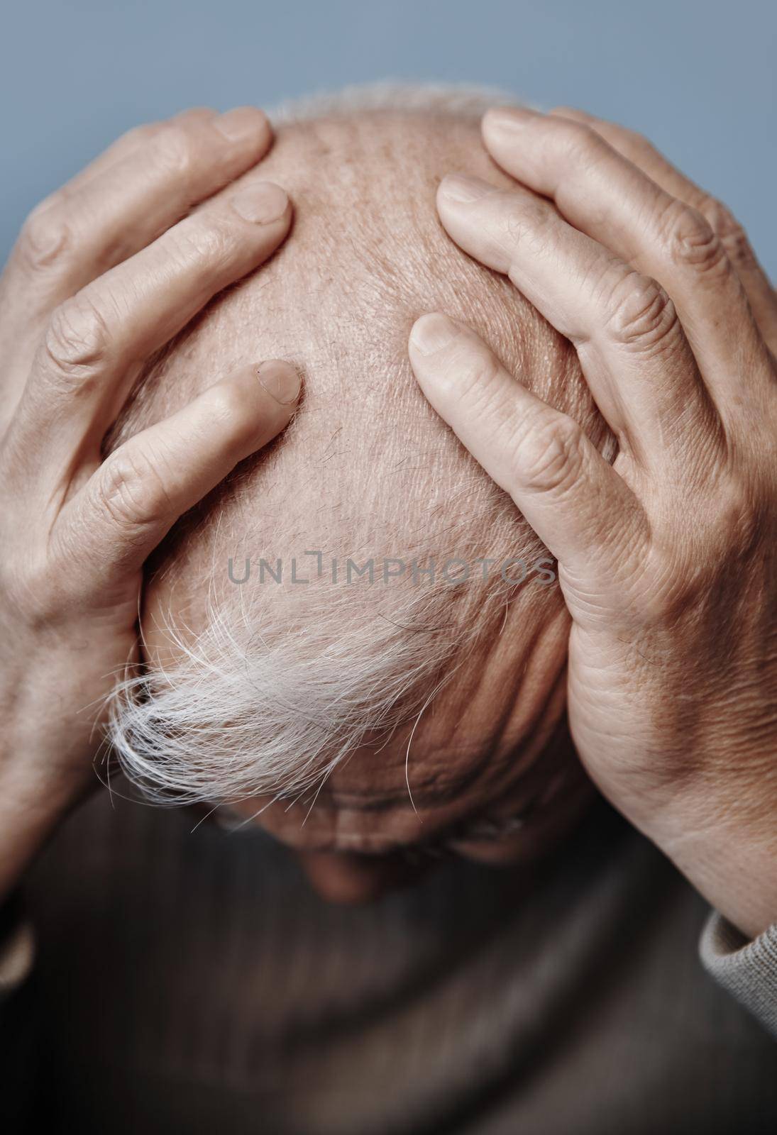 Senior man holding her head in pain while feeling headache