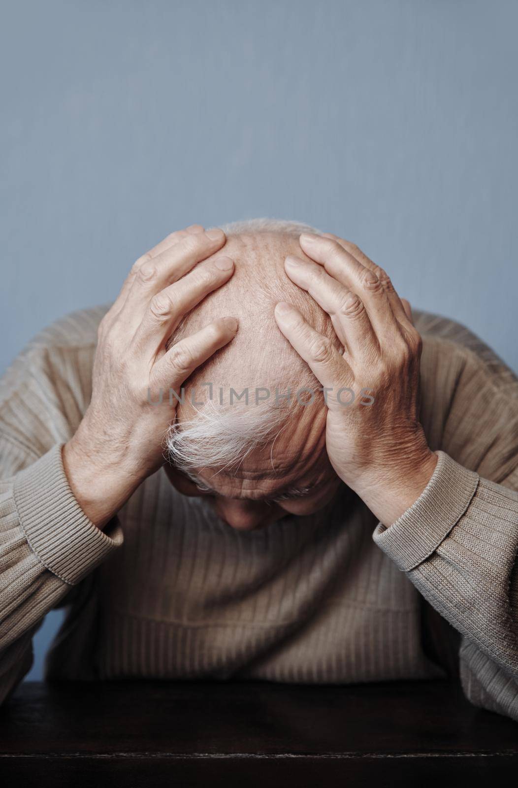 Senior man holding her head in pain while feeling headache by Novic