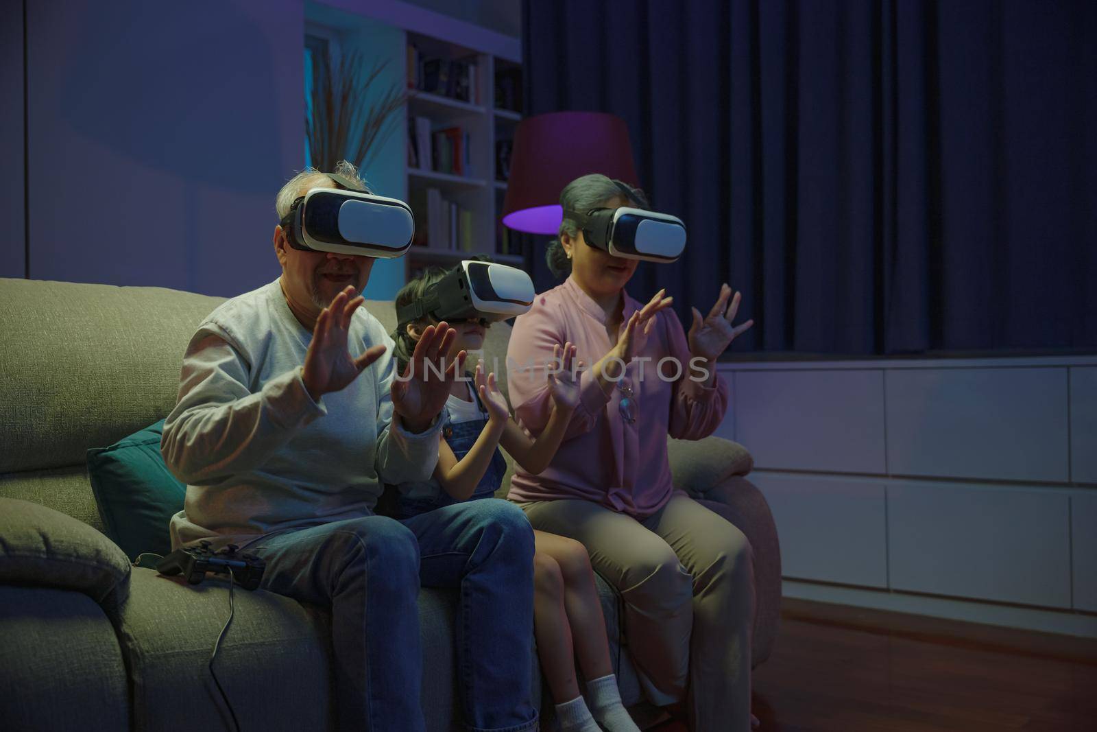 Asian granddaughter and grandparents playing together exciting interesting video games using virtual reality headsets living room at home, elderly with child play VR video game, family entertainment