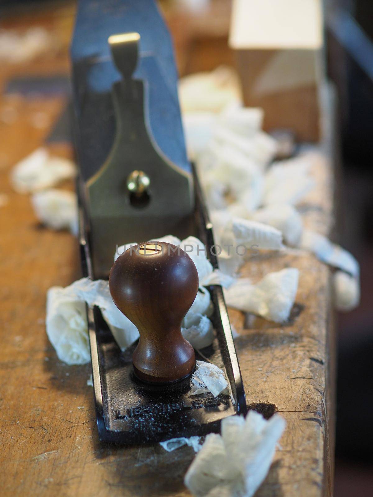 Close up of professional master artisan luthier painstaking detailed work on wood violin in a workshop.