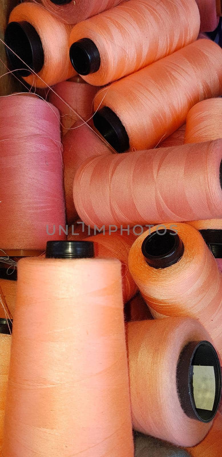 Colorful yarn on spool, yarn on tube, cotton, wool, linen thread orange